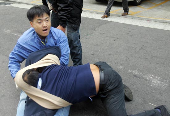 기륭전자 직원이 한 시민을 끌어 당겨 넘어뜨리고 있다.[사진-통일뉴스 조성봉 기자]