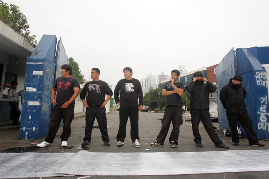 사측에서 고용한 용역직원들이 정문을 지키고 서 있다. [사진-통일뉴스 조성봉 기자]