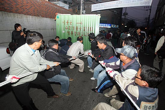 사측에 의해 강제철거된 '컨테이너 농성장'을 시민들이 밧줄로 옮기고 있다. [사진-통일뉴스 조성봉 기자]