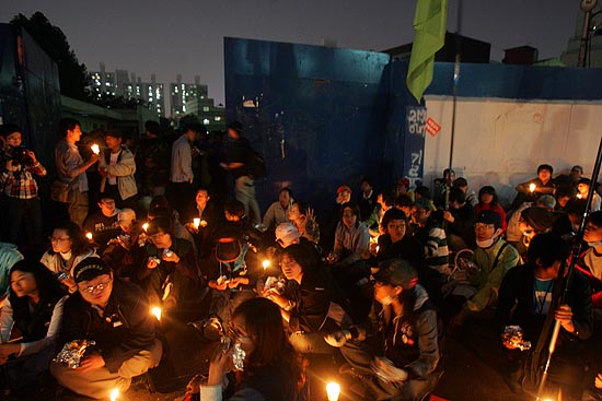 촛불을 들고 기륭전자 정문에서 '컨테이너 농성장'을 지키고 있는 시민들. [사진-통일뉴스 조성봉 기자]