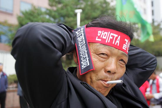 머리끈을 묶는 농민 참가자. [사진-통일뉴스 조성봉 기자]