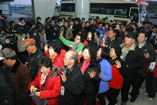 개성관광을 마치고 돌아온 관광객들이 카메라 기자들을 향해 손을 흔들고 있다.[사진-통일뉴스 조성봉 기자]