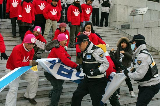 퍼포먼스를 끝마치고 기자회견을 진행하는 도중, 경찰이 이명박 대통령을 비판하는 플랜카드를 빼앗으려고 달려 들었다.[사진-통일뉴스 조성봉 기자]