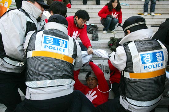 경찰이 플랜카드를 빼앗으려 잡아당기고 있다.[사진-통일뉴스 조성봉 기자]