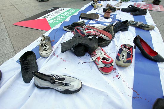 이스라엘 국기 위에 신발들이 널려져 있다. 이는 부시 미 대통령에게 신발을 던지 이라크 기자의 행동에서 고안한 상징의식이다. [사진-통일뉴스 조성봉 기자]