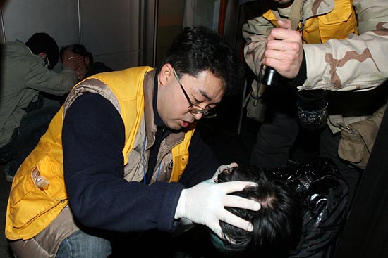 방패로 찍히고, 전경들이 던진 돌에 맞아 머리가 찢어져 응급치료를 받고 있는 시민들.[사진-통일뉴스 조성봉 기자]