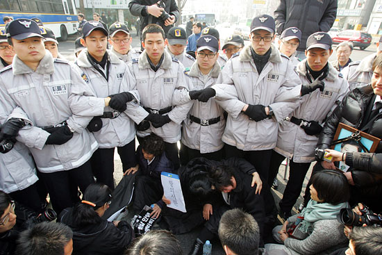 경찰이 항의서한 전달을 가로막자 자리에 주저 앉아버린 유가족들.[사진-통일뉴스 조성봉 기자]