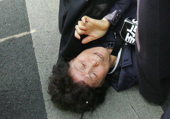 경찰에 가로막히자, 스크럼을 짠 경찰 다리 사이로 빠져나오려 몸부림을 치고 있는 유가족.[사진-통일뉴스 조성봉 기자]