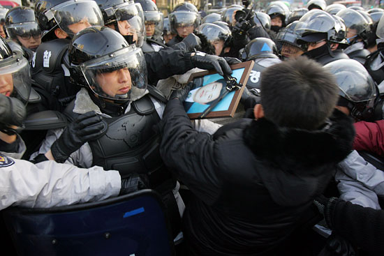 유가족들이 프라자호텔 앞에서 추모행진을 시도하자 경찰은 영정사진을 빼앗으며 이를 저지했다[사진-통일뉴스 조성봉 기자]