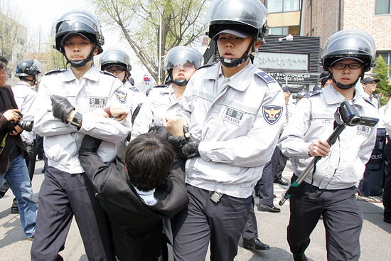 경찰이 기자회견에 참석한 한 대학생의 사지를 들고 연행해 가고 있다.[사진-통일뉴스 조성봉 기자]