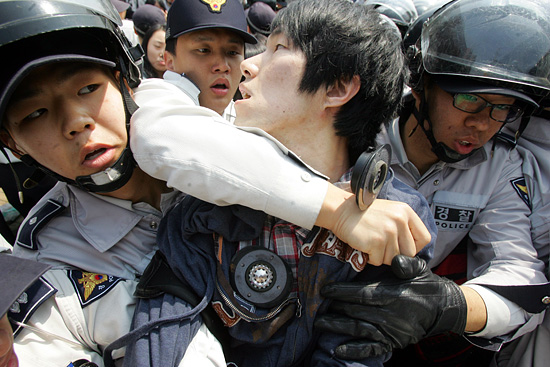 경찰이 기자회견에 참석한 한 대학생의 양팔을 잡고 목을 조르며 연행하고 있다.[사진-통일뉴스 조성봉 기자]