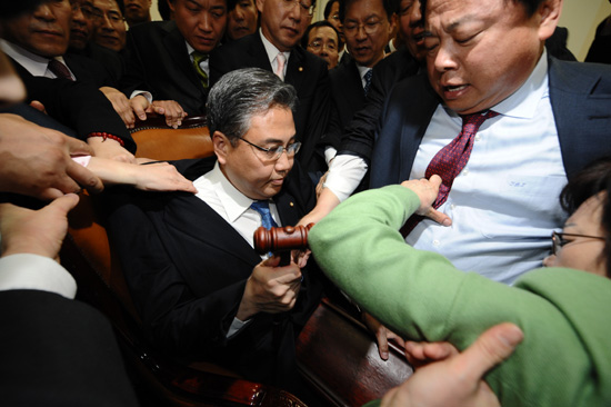 오전 11시 45분께 국회 외교통상통일위원회에서 박진 위원장이  '한.미FTA 비준동의안'처리를 시도하자 이를 저지하려는 여야 의원들이 뒤엉켜 몸싸움을 하고 있다. 이날 박진 위원장은 의사봉 대신 주먹으로 책상을 세번 내리치고 한.미FTA 처리를 선언했다. [사진-인터넷신문공동취재단]