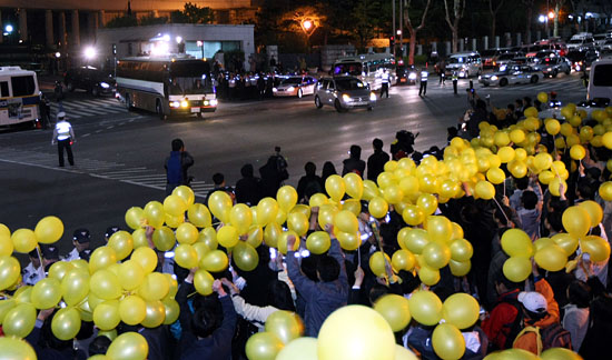 1일 새벽 노무현 전 대통령이 조사를 마치고 봉화마을로 출발하려 대검찰청 정문을 통과하고 있는 가운데 노사모회 회원들과 지지자들이 풍선을 흔들며 격려와 응원을 보내고 있다.[사진-인터넷사진공동취재단]