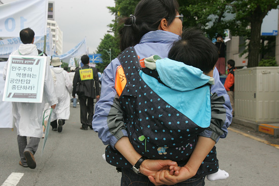 '5.18 자주통일대행진'에서는 아이를 업고 참가한 어머니의 모습도 눈에 띄었다.[사진-통일뉴스 조성봉 기자]
