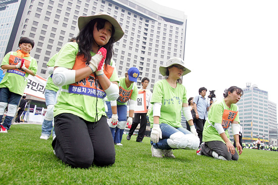 해고 반대, 원직 복귀와 쌍용자동차에 대한 정부의 적극적인 대책을 촉구하며 정성스럽게 삼보일배를 드리는 쌍용자동차 가족들.[사진-통일뉴스 조성봉 기자]