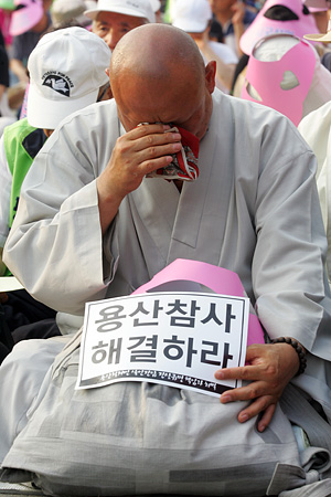 용산 유가족이 편지를 읽고 있는 가운데, 한 스님이 눈물을 흘리고 있다.[사진-통일뉴스 조성봉 기자]