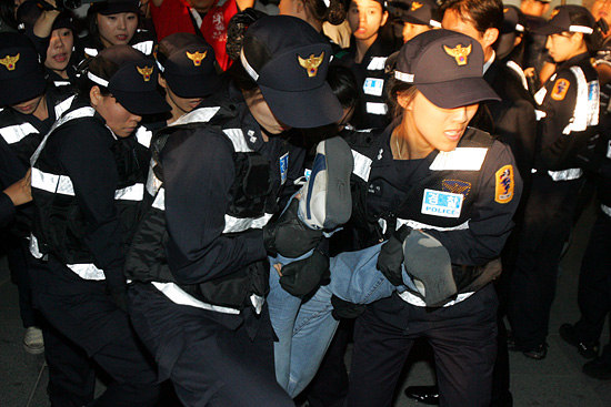 경찰이 광화문 광장 계단에 앉아 있던 1인 시위 참가자의 사지를 들고 강제로 연행하고 있다. [사진-통일뉴스 조성봉 기자]