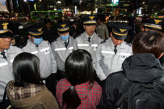 '천안함' 실종들의 무사귀환과 희생자를 추모하는 대학생들을 둘러싼 경찰들. 촛불과 피켓을 빼앗긴 대학생들은 30분만에 자진해산했다.[사진-통일뉴스 조성봉 기자]