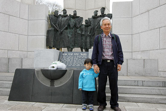4.19 50주년을 맞이하는 19일 오후, 4.19혁명 당시 시위에 참여했던 서종무씨(당시 고2)와 손자가 기념탑을 배경으로 사진을 찍고 있다.[사진-통일뉴스 조성봉 기자]