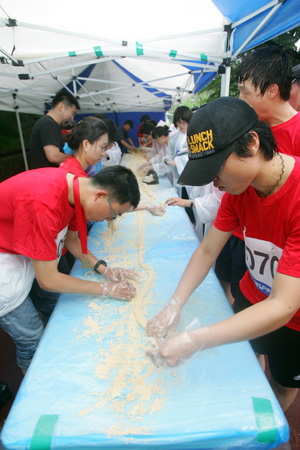 참가자들이 6.15남북공동선언 발표 10돌을 기념해 615cm떡을 만들고 있다.[사진-통일뉴스 조성봉 기자]