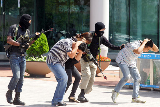 테러범들이 킨텍스 전시장에 있는 시민들을 인질로 잡고 건물 밖으로 나오고 있다.[사진-통일뉴스 조성봉 기자]