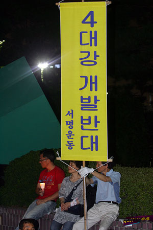 한 시민이 만장을 들며'4대강개발 반대 서명운동'을 촉구하고 있다.[사진-통일뉴스 조성봉 기자]