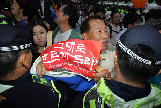 경찰이 인간띠잇기 행사를 원천봉쇄하자 손 피켓을 들고 한 시민이 거세게 항의하고 있다.[사진-통일뉴스 조성봉 기자]