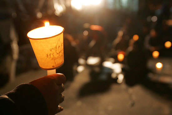 기륭전자 노동자들이 '일터로 돌아가고 싶은  꿈'을 담아 촛불을 들고 있다.[사진-통일뉴스 조성봉 기자]