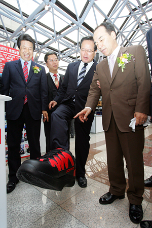 정의화 국회부의장(한나라당 소속)이 개성공단에서 만든 대형 신발을 신고 걷자 김충환의원이 