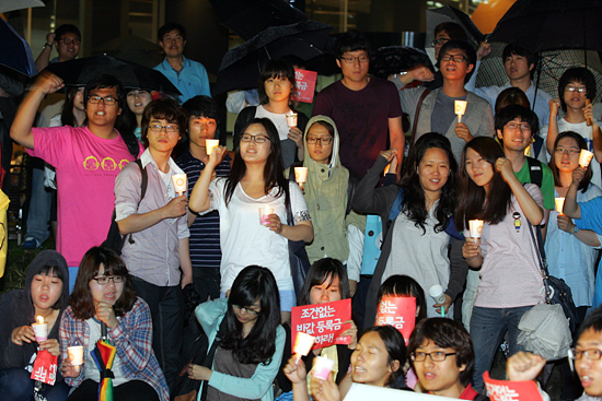비가 오는 가운데에도 아랑곳하지 않고 촛불을 들고 '반값등록금 실시'를 외치는 100여명의 대학생들과 시민들.[사진-통일뉴스 조성봉 기자]