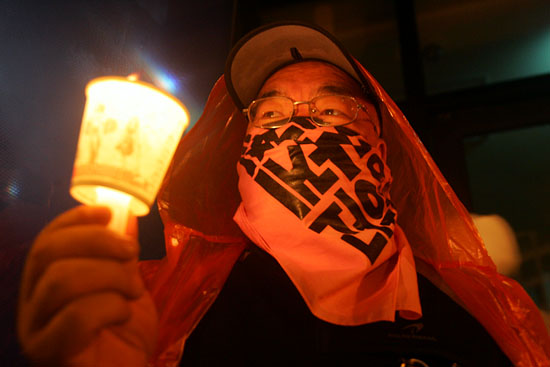 경찰의 차벽에 행진이 가로막히자 참가자들은 하나둘 촛불을 들고 '정리해고 철회!', '김진숙 지도위원 면담'을 요구했다. [사진-통일뉴스 조성봉 기자]