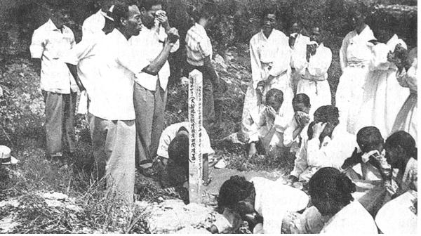 1960년, 달성군 가창면 민간인 학살 사건으로 숨진 대구지구 희생자의 공동분묘 앞에서 상복 차림의 유가족들이 묘 표지를 세운 뒤 오열하고 있다.