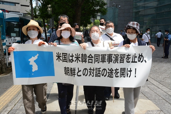 항의행동 참가자들이 횡단막과 플랭카드를 들고 주일 미국대사관을 향해 행진하고 있다. [사진-조선신보]
