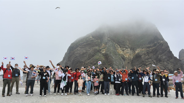 동도 선착장에 내린 탐방객. 뒤에 서도가 보인다.