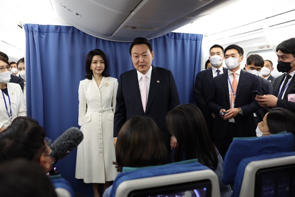 지난해 6월 첫 순방 때 기내에서 취재진과 인사하는 윤 대통령 부부. [사진제공-대통령실]