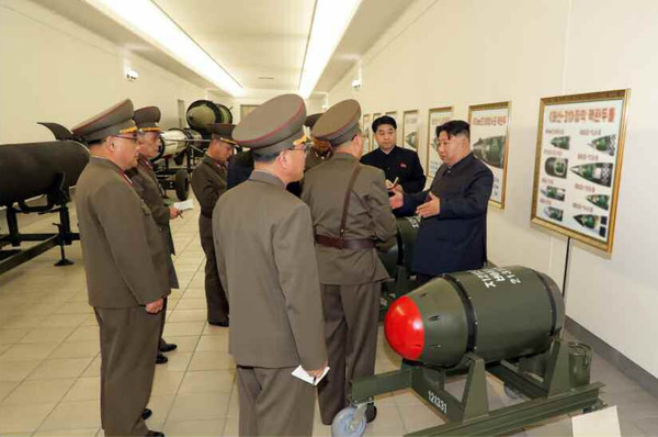 김 위원장 뒷편에 걸려있는 패널에는 ' 화산-31'장착 핵탄두들'이라는 제목으로 여러 종류의 미사일에 핵탄두가 장착된 '전투부' 도식 8장이 눈에 띈다. [사진-노동신문 갈무리]