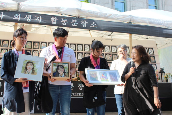 박향미 작가가 유가족에게 작품을 전달하고 있다. 아버지의 눈시울이 금세 붉어진다. [사진-통일뉴스 이승현 기자]