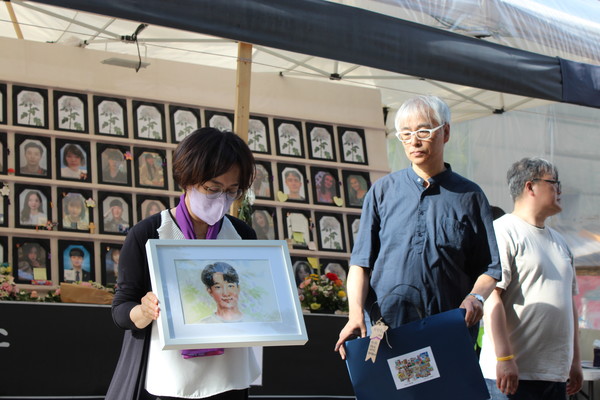 이진석 작가가 유가족에게 작품을 전달하고 있다. [사진-통일뉴스 이승현 기자]