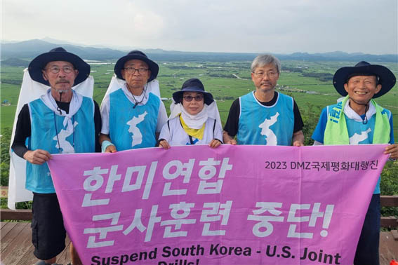 소이산 정상에서 한미 연합군사훈련 중단, 평화협정 체결, 공동선언 이행을 요구하는 인증샷을 남겼다. [사진 - DMZ 국제평화대행진단]