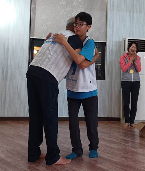 조헌정 단장께는 행진단의 최연소자인 중학교 1학년 윤경준 학생이 메달을 걸어드리고 포옹하니 참석자들이 모두 환호성을 질렀다. [사진 - DMZ 국제평화대행진단]