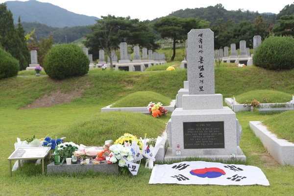 한 시민이 대전현충원 홍범도 장군 묘 앞에 태극기를 펼쳐놓았다. [사진-통일뉴스 임재근 객원기자]