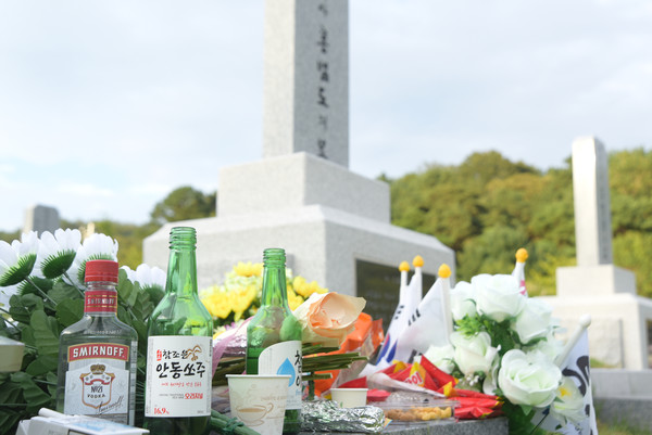 홍범도 장군 묘 앞에 많은 사람들이 놓고 간 꽃과 술, 음식들이 놓여 있다. [사진-통일뉴스 임재근 객원기자]