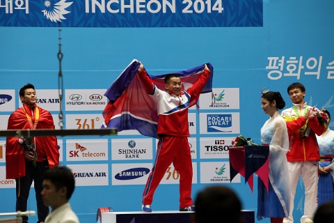 2014년 인천 아시안게임 역도에서 금메달리스트로 시상대에 올라 공화국기를 흔드는 엄윤철 선수. [통일뉴스 자료사진]