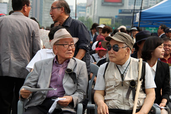 2013년 6월 열린 민족민주열사 범국민추모제에서 밀양초등학교 2년 후배인 박중기 추모연대 이사장(왼쪽)과 함께. 박중기 이사장은 1964년 1차 인혁당, 1974년 2차 인혁당 사건으로 구속됐고, 특히 2차 구속 때 받은 전기고문 후유증으로 한쪽 눈이 실명되는 등 고초를 겪기도 했다. 아버지와는 고향 선후배로 각별한 친분을 나누었다. [사진 제공 – 안영민]