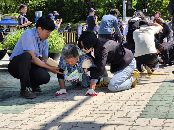 걷기 조차 힘든 성치않은 무릎으로 민주유공자법 국회 통과를 위한 의지로 오체투지에 나선 열사의 어머니를 장혜영 정의당 의원이 부축하며 함께 하고 있다. [사진-통일뉴스 이승현 기자]