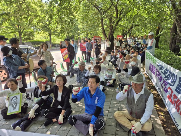 오체투지 참가자들이 국회 의원회관 옆에서 잠시 쉬어가며 민주유공자법 국회 본회의 통과 촉구하는 구호를 외치고 있다. [사진-통일뉴스 이승현 기자]