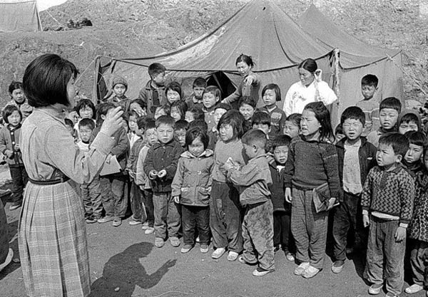 교사가 불타버리는 바람에 임시로 천막교실에 수업을 하는 초등학생들. [사진 제공 – 안영민]