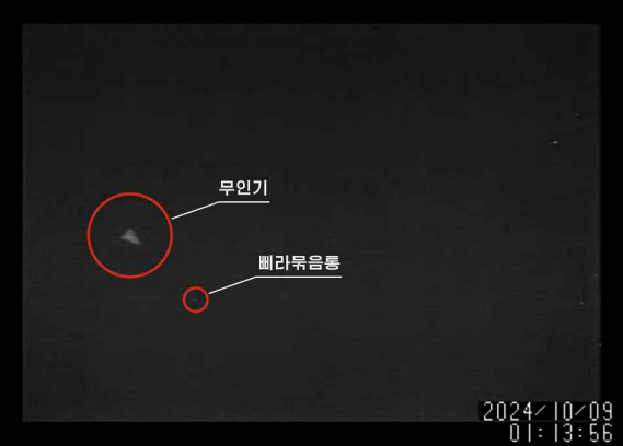 10월 9일 새벽 1시 13분 56초에 찍힌 무인기와 삐라 묶음통. 조선로동당 청사구역 상공에서 삐라를 살포하는 적 무인기라는 제목으로 [노동신문]이 12일 공개했다. 10초 전에 찍힌 무인기 사진에는 '조선로동당 중앙위원회 본부청사 상공에 출현한 적무인기'라는 설명을 달았다. [사진-노동신문] 