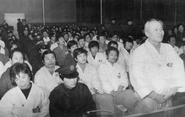 법정에서 진술하는 이재문 선생. 맨 앞줄 교도관 옆에 앉아 있는 사람이 신향식 선생이다. 이재문 선생 바로 뒤편에 보이는 사람이 옥중에서 두 분의 추모시인 전사1, 전사2를 쓴 김남주 시인이다. [사진 제공 – 안영민]