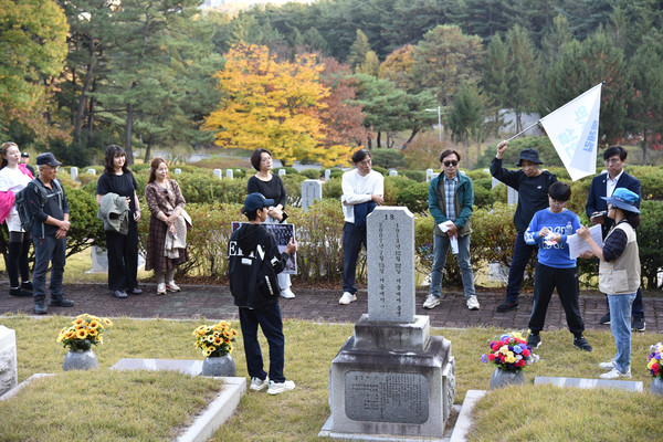 1코스 참가자들이 사회공헌자묘역에 안장된 민복기의 묘 앞에서 윤석림 해설사의 이야기를 듣고 있다. [사진-통일뉴스 임재근 객원기자]